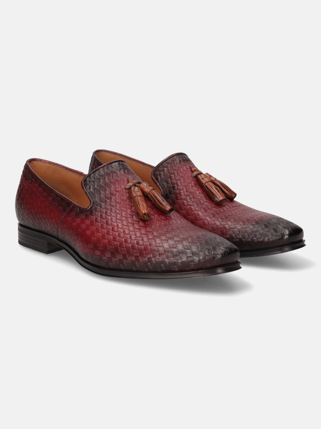 Red leather slip-on shoes by bugatti with a woven pattern and decorative tassels.