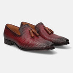 Red leather slip-on shoes by bugatti with a woven pattern and decorative tassels.