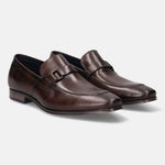 A brown Men's bugatti Bit Loafer featuring a round toe apron toe, stacked heel. Made from premium genuine leather with a durable high quality synthetic outsole, this slip-on design offers both style and comfort.