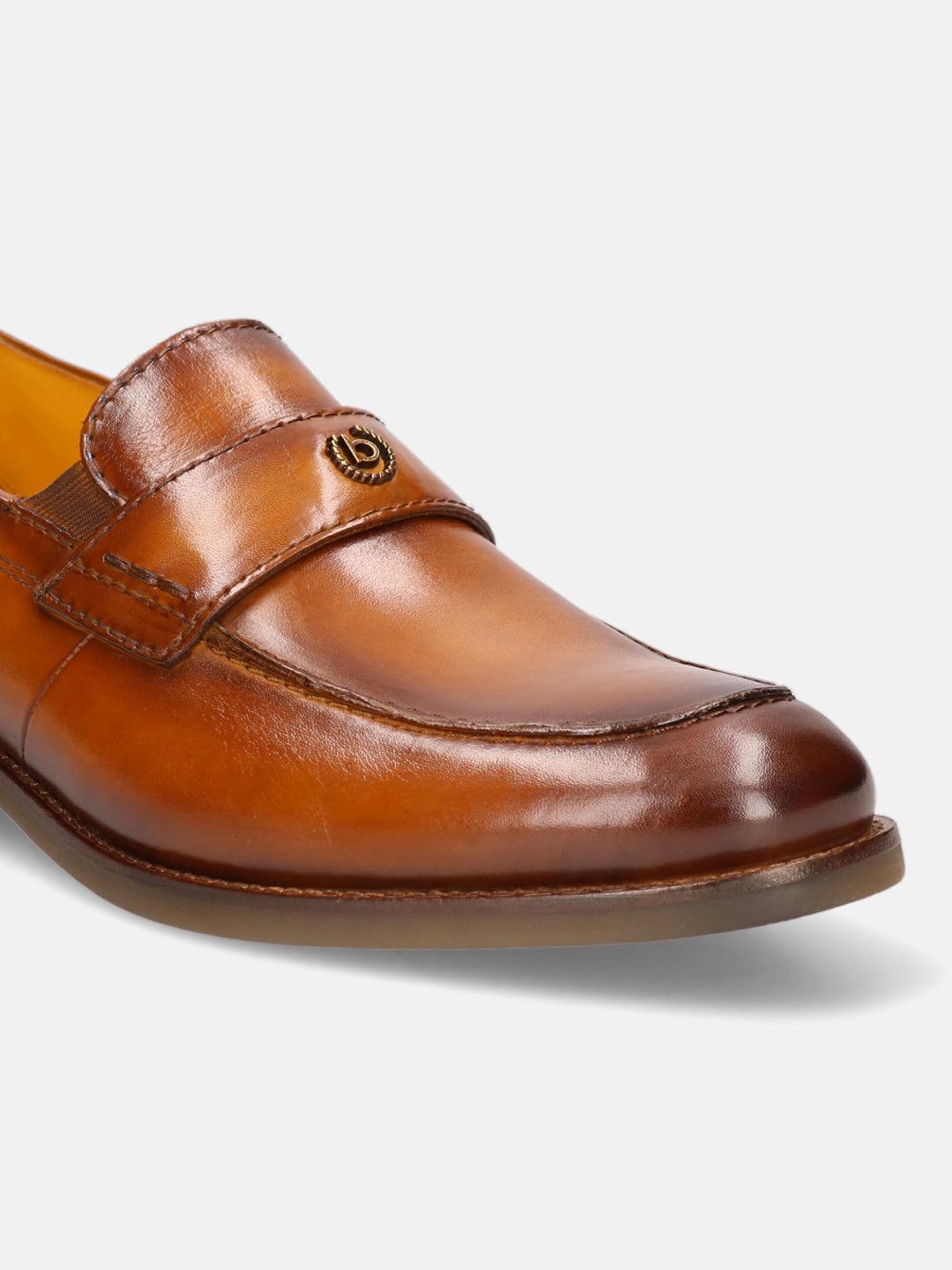 Brown leather penny loafer by Bugatti, featuring a decorative metal logo.