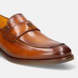 Brown leather penny loafer by Bugatti, featuring a decorative metal logo.
