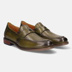 Green leather penny loafers by bugatti, showing top stitching, logo detail on the strap, and a wood-look heel.
