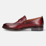Red leather penny loafer by bugatti with a classic design and a low heel.