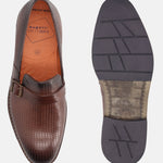 Brown leather penny loafers by bugatti, with perforated texture, decorated with a dark brown strap and buckle.