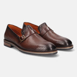 Brown premium leather penny loafers by bugatti, featuring a textured and perforated upper and subtle buckled strap.
