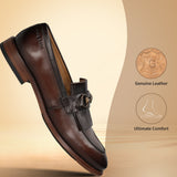 Bugatti Liverta premium leather slip-on shoe in dark brown, shown at an angle, featuring a decorative buckle.