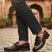 bugatti Liverta dark brown leather slip-on dress shoes with a decorative fringe, worn with gray pants.