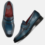 Dark blue leather slip-on formal shoes by bugatti, featuring a red insole and tonal stitching.
