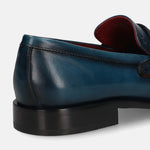 Dark blue leather loafer by bugatti with black soles, displayed in a back angle view.