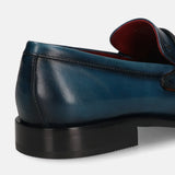 Dark blue leather loafer by bugatti with black soles, displayed in a back angle view.