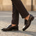 Bugatti Mansueto Flex Revo dark brown leather slip-on shoe, worn with dark brown dress pants.

