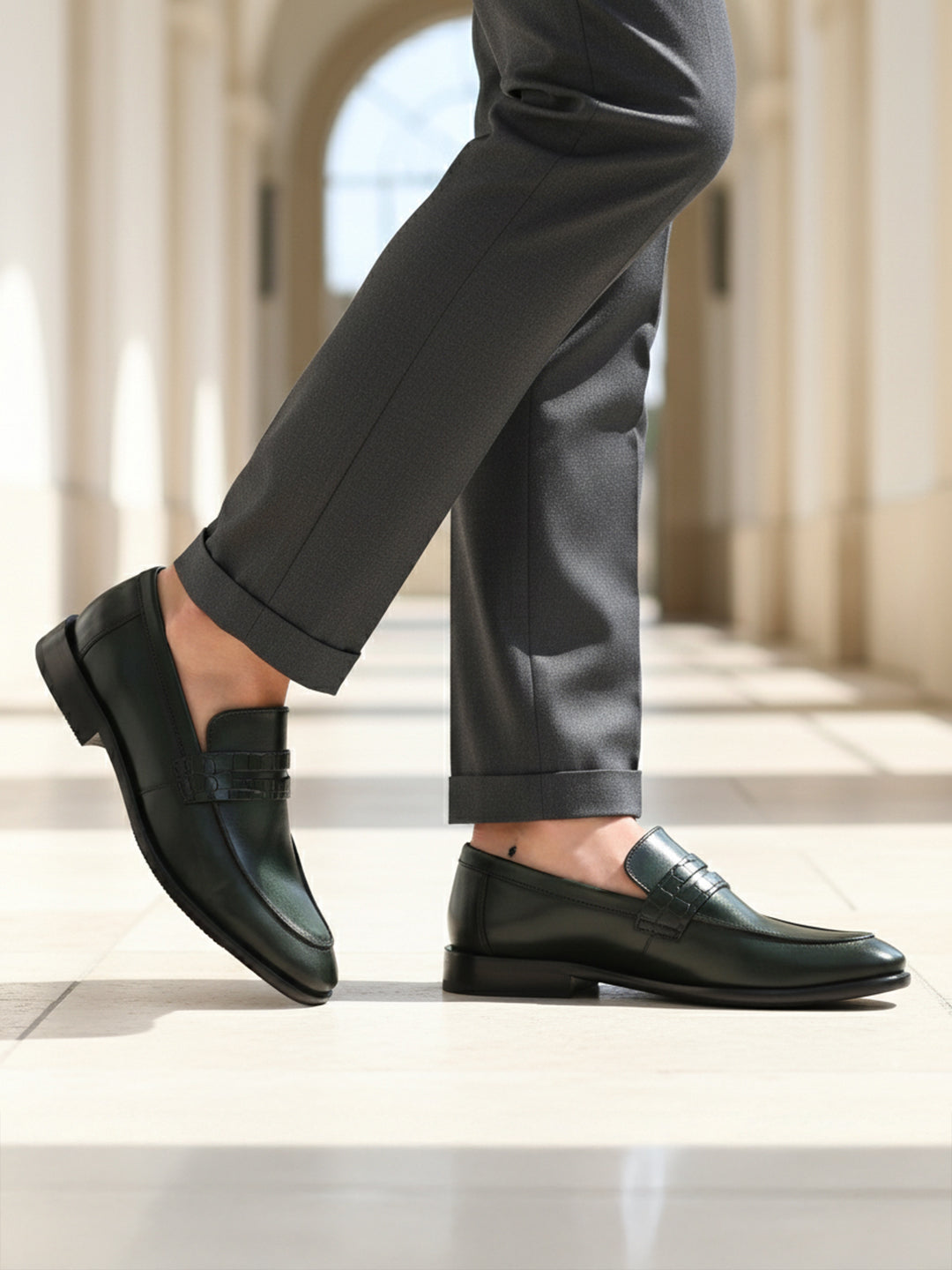 bugatti Mansueto Flex Revo penny loafers in dark green premium leather worn with grey dress pants.
