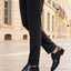 bugatti Lark flex dark blue leather derby shoes with brown laces, shown with gray trousers and a sidewalk.
