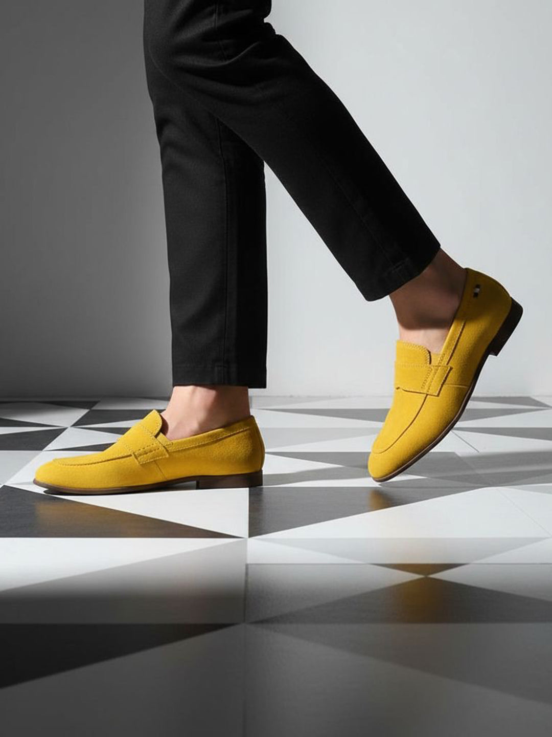 Yellow leather loafers by bugatti on black and white checkered flooring, paired with black trousers.