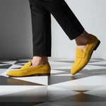 Yellow leather loafers by bugatti on black and white checkered flooring, paired with black trousers.