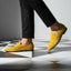 Yellow leather loafers by bugatti on black and white checkered flooring, paired with black trousers.