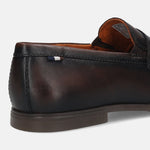 Dark brown leather penny loafer by bugatti with a decorative stripe on the heel.
