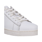 Cropped view of a white bugatti sneaker with white laces and a textured sole.
