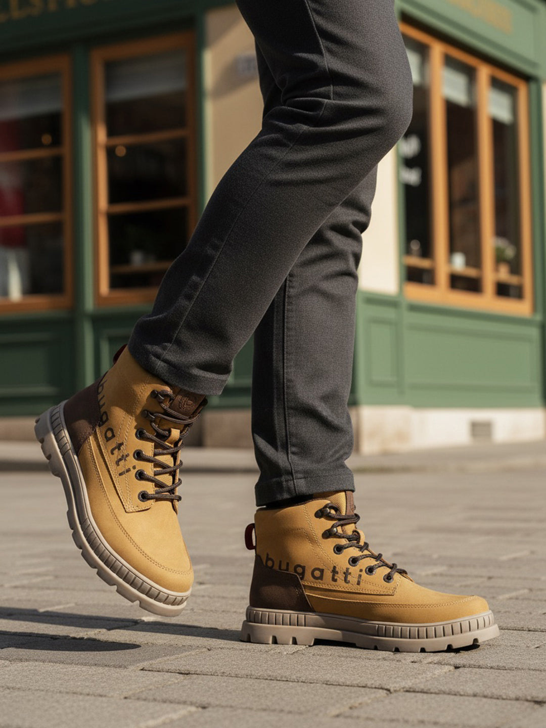 Lifestyle shot of bugatti Pallario beige comfort casual boots with dark brown accents, worn with grey pants.
