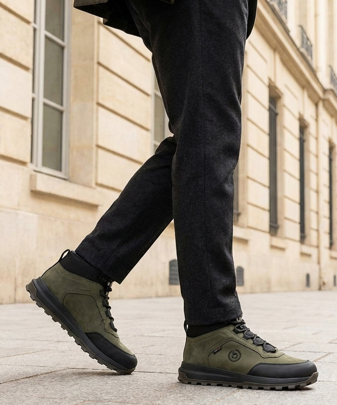 Lifestyle shot of bugatti Columb Dark Green Comfort Sneakers, worn with dark gray pants and olive green coat.