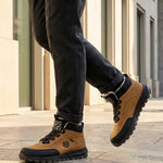 Lifestyle view of bugatti Columb Cognac Comfort Sneakers, with dark trousers and light-colored building in the background.