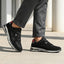 bugatti Parry black premium leather sneakers shown on a model wearing gray dress pants.
