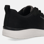 Cropped shot of a black bugatti Astra sneaker, showing the textured upper, heel tab, and wavy white sole.
