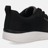 Cropped shot of a black bugatti Astra sneaker, showing the textured upper, heel tab, and wavy white sole.
