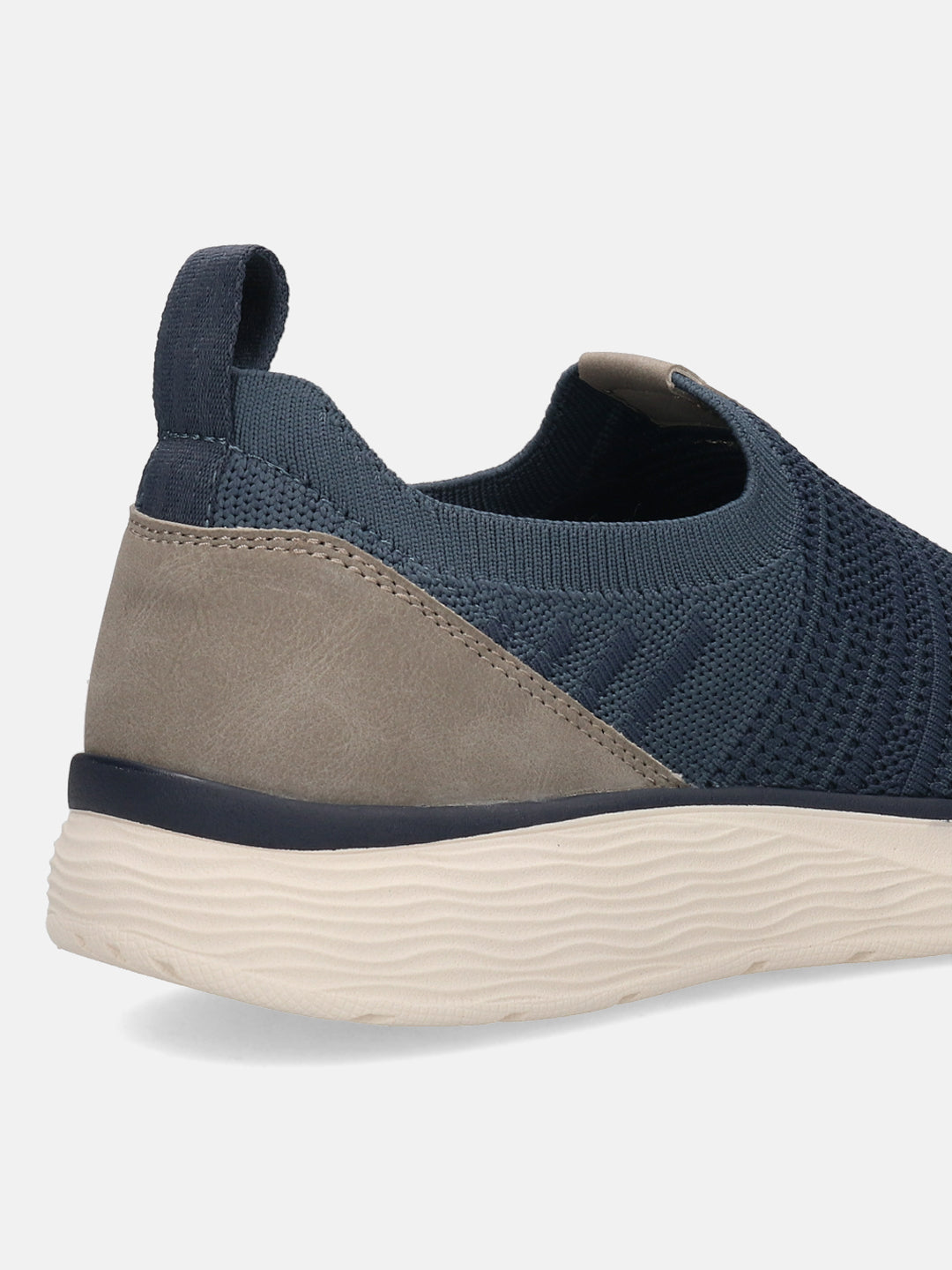 Cropped view of a blue knit bugatti slip-on shoe with a textured sole and a grey heel detail.
