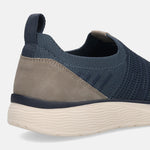 Cropped view of a blue knit bugatti slip-on shoe with a textured sole and a grey heel detail.
