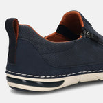 Back view of a dark blue bugatti slip-on shoe with perforated detail, tan lining, a zipper, and a heel pull tab.
