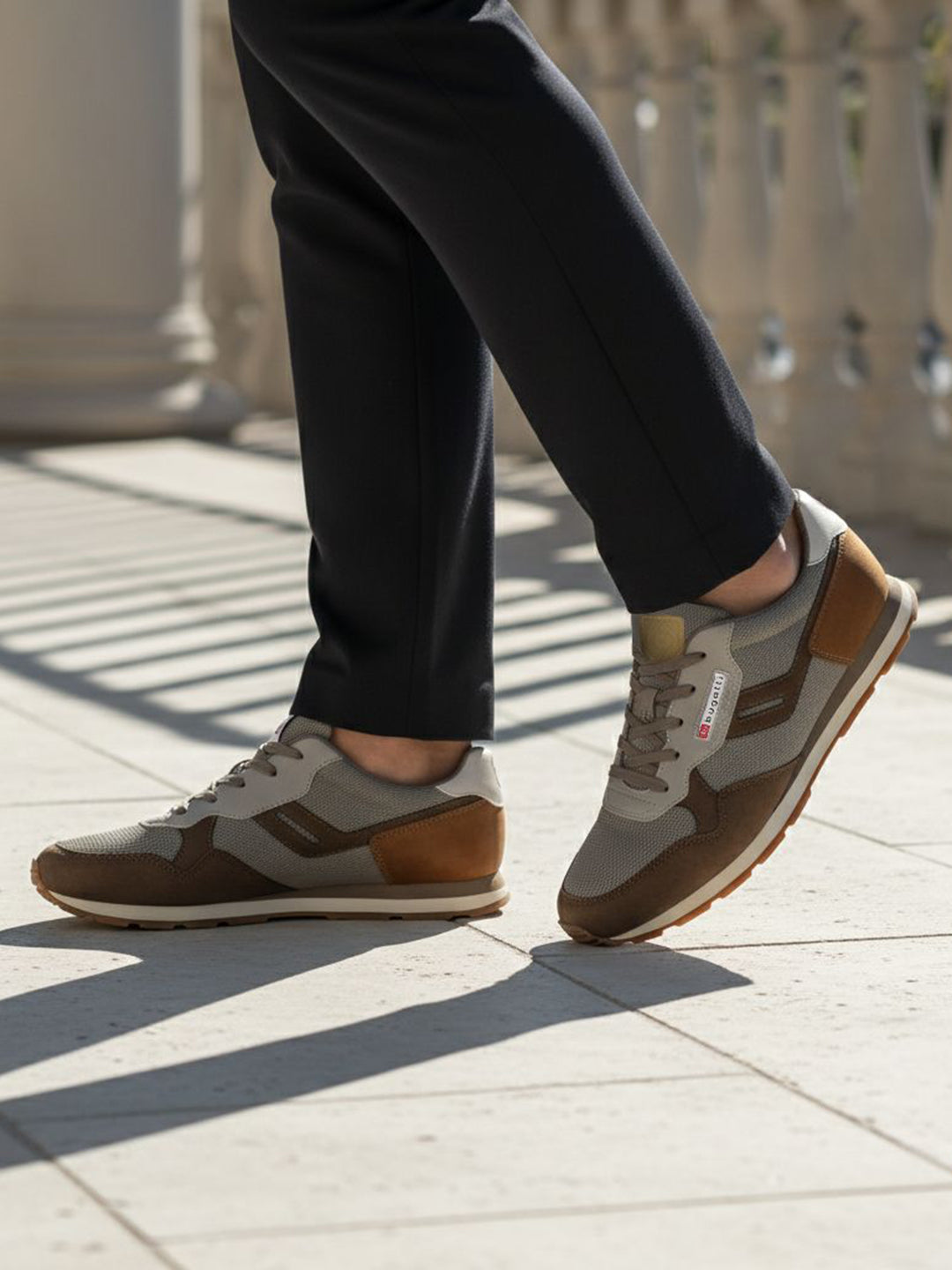 Lifestyle view of bugatti Sacramento brown comfort sneakers featuring a brown suede and gray textile design.
