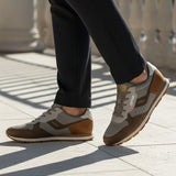Lifestyle view of bugatti Sacramento brown comfort sneakers featuring a brown suede and gray textile design.
