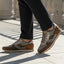 Lifestyle view of bugatti Sacramento brown comfort sneakers featuring a brown suede and gray textile design.
