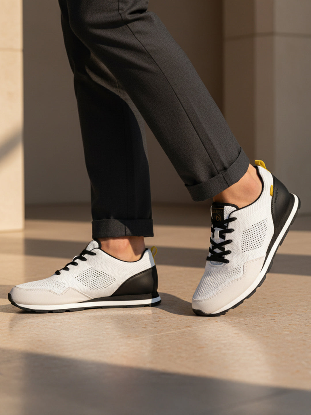 bugatti Sacramento white comfort sneakers with black heel, worn with gray dress pants.
