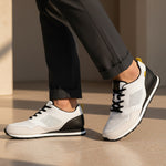 bugatti Sacramento white comfort sneakers with black heel, worn with gray dress pants.
