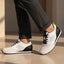 bugatti Sacramento white comfort sneakers with black heel, worn with gray dress pants.
