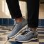 bugatti Sandar blue athleisure sneakers with black laces and white soles, paired with black cuffed pants.
