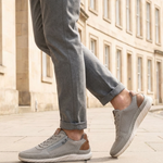 Lifestyle view of bugatti Compton grey comfort sneakers with mesh fabric, leather trim, zipper detail, and white soles.
