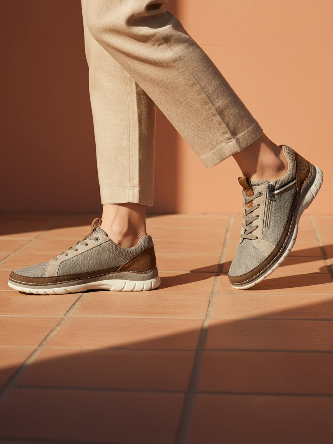 Lifestyle shot of bugatti Rickson beige Comfort Sneakers with zipper detail and brown accents, paired with neutral pants.
