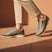 Lifestyle shot of bugatti Rickson beige Comfort Sneakers with zipper detail and brown accents, paired with neutral pants.
