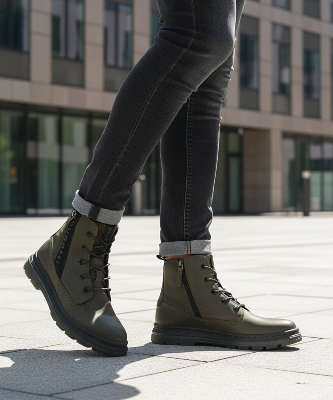 Lifestyle shot of Bugatti Drake boots in dark green leather with laces and side zipper, paired with dark denim jeans.