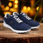 bugatti Atus dark blue sneakers with white laces and soles on a wooden surface with a blurred background.
