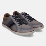 Grey low top sneakers by bugatti featuring dark laces and brown leather heel patch.