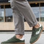 Lifestyle shot of bugatti Carmelo dark green Comfort Sneakers with a white stripe and brown sole.
