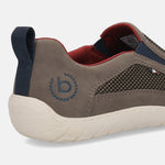 Cropped back view of a bugatti dark grey casual slip-on shoe with a textured white sole and navy pull tab.
