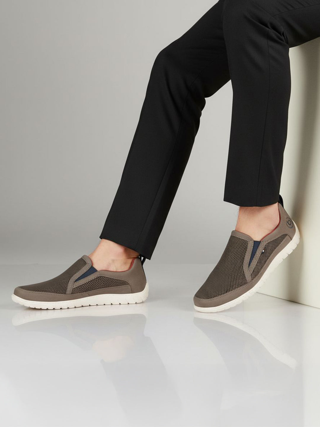 Lifestyle shot of bugatti Bermudas dark gray casual slip-on shoes with a breathable mesh upper and white sole.
