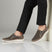 Lifestyle shot of bugatti Bermudas dark gray casual slip-on shoes with a breathable mesh upper and white sole.
