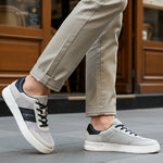Lifestyle shot of bugatti Mackay light grey comfort sneakers with a black accent and white sole.
