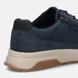 Back view of a dark blue bugatti Comfort Sneaker with a zipper detail, set on a textured tan and brown sole.
